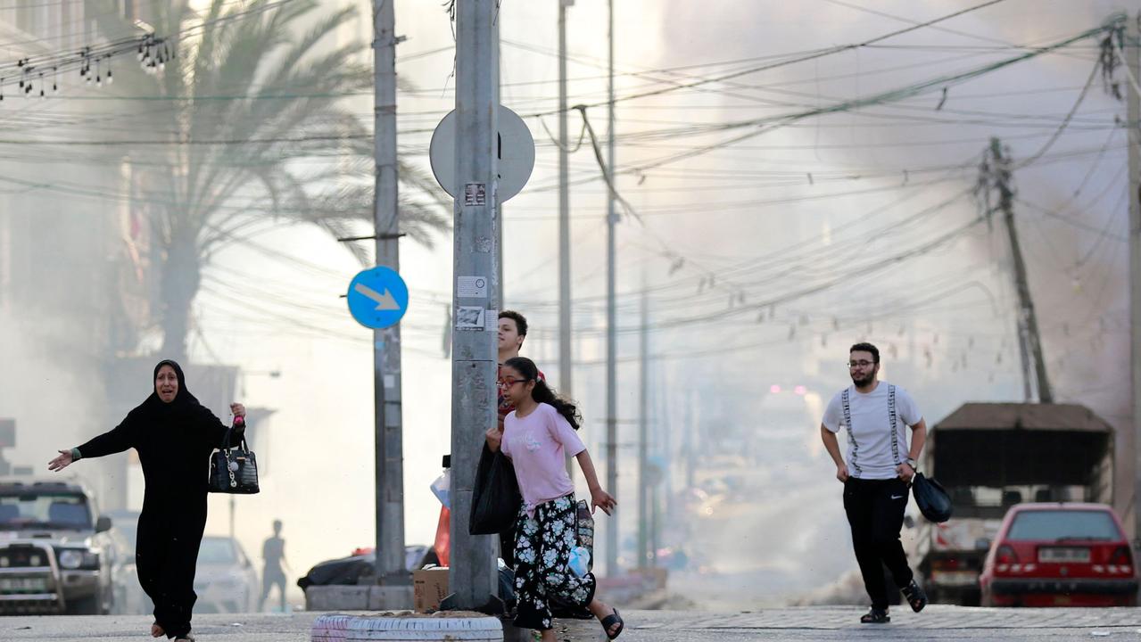 Palestinians run for cover after a strike near the Al-Shifa hospital in Gaza City on November 1, 2023, amid the ongoing battles between Israel and the Palestinian group Hamas. (Photo by Bashar TALEB / AFP)