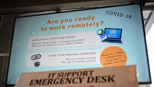 A screen promoting remote working using a laptop or a mobile phone is displayed at the World Health Organization (WHO) headquarters in Geneva to promote the fight against COVID-19, the disease caused by the novel coronavirus, on March 11, 2020 in Geneva. - More governments and companies are encouraging employees to work from home as nations scramble to contain the virus. (Photo by Fabrice COFFRINI / AFP)