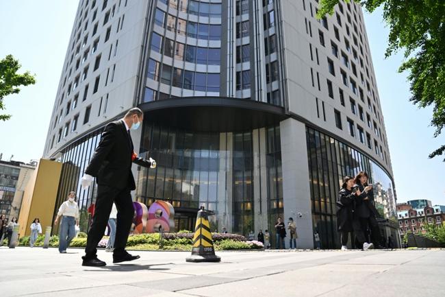 A man walks past the entrance of the building where Canada's consul general facilities are located in Shanghai on May 9, 2023.