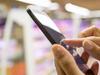 Woman using mobile phone while shopping in supermarket