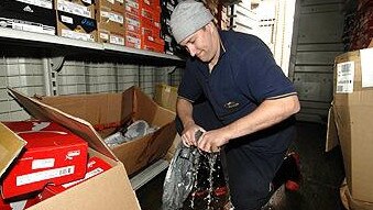 Feeling the squeeze: Brad Duncan wrings water out of sporting goods at his store in Lakes Entrance. Picture: Jay Town.