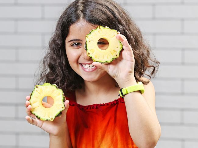 Donya Mohseni, 8, enjoying pineapples from Fruity Capers &amp; Deli in Toowong Village. Picture: Tara Croser