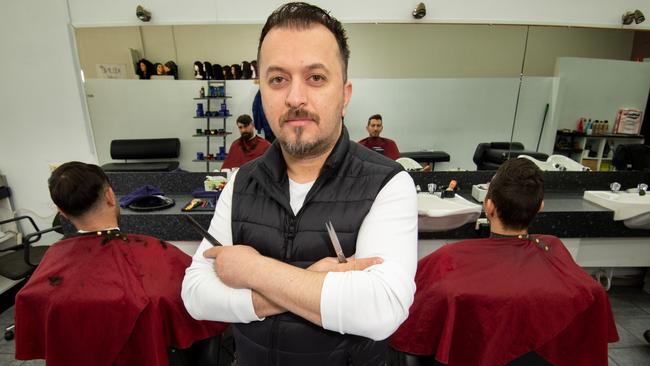 Barber Mehmet Akar said he was expecting a sharp decline in customers coming into his Dallas business. Picture: Tony Gough