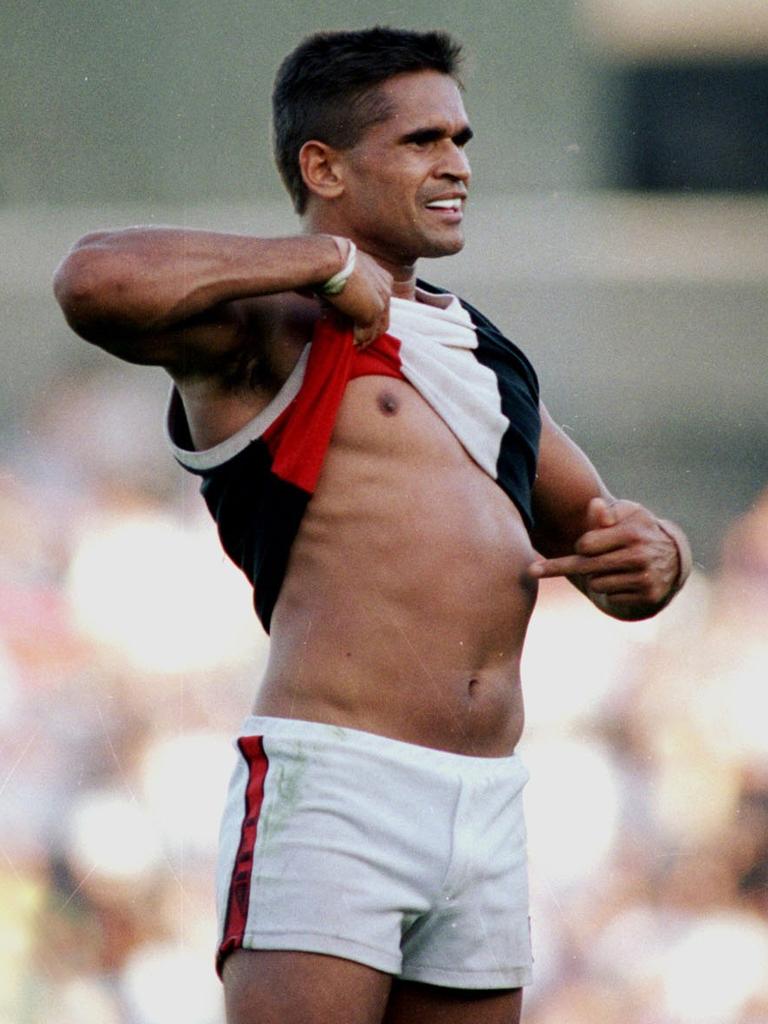 Nicky Winmar lifts his jumper and points to the colour of his skin after he was subjected to racial abuse by Collingwood supporters.