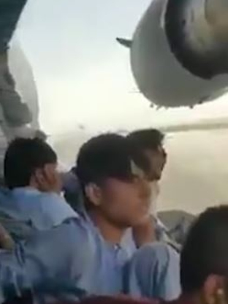 Young men cling to the landing gear of a plane leaving Kabul. Picture: Twitter