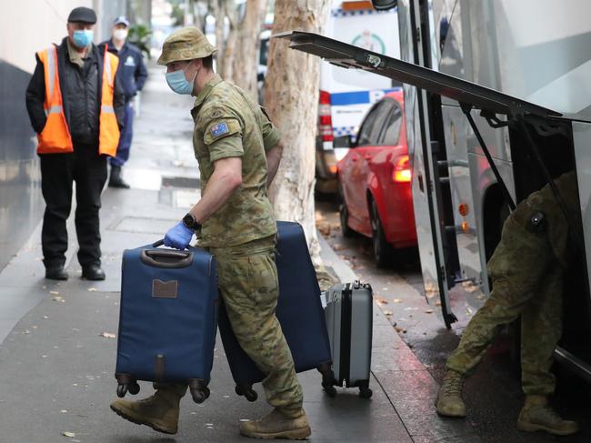 Police and Army personnel help direct travellers into mandatory hotel quarantine at the Travelodge Hotel in Darlinghurst. Picture: Tim Hunter