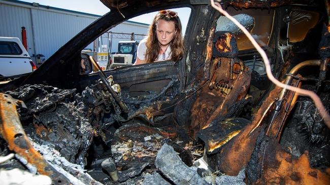 The young mum inspects the devastated car. Picture: Mark Stewart