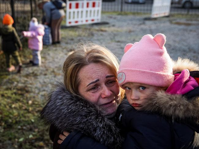 TOPSHOT - Svetlana Titova, 52, hugs her granddaughter as they arrive from the Russian-held town of Berdyansk, at a humanitarian relief centre in the central Ukrainian city of Zaporizhzhia on November 7, 2022, amid the Russian military invasion on Ukraine. - Psychiatrists at the humanitarian relief centre prepare to receive those displaced by war, offering them immediate counselling and further guidance. (Photo by ANATOLII STEPANOV / AFP)