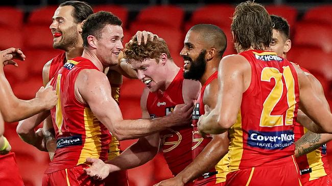 Matthew Rowell is mobbed by teammates after kicking his first AFL goal.