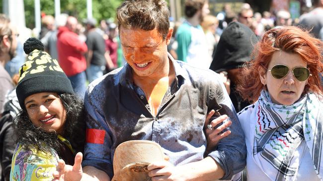 A man is helped away from the crowd after being on the receiving end of pepper spray. Picture: Mike Keating.