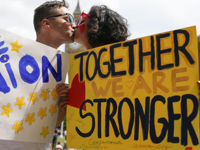 People pose kissing each other in a kiss chain organised by pro-Europe 'remain' campaigners seeking to avoid a Brexit in the EU referendum in Parliament Square in front of the Houses of Parliament in central London on June 19, 2016. / AFP PHOTO / Daniel Leal-Olivas