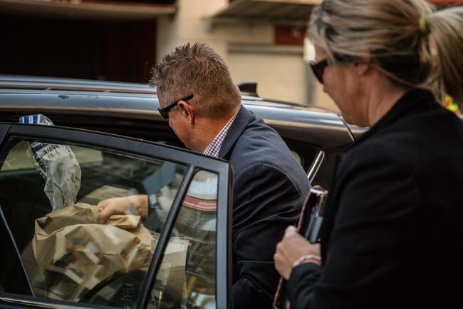 Detectives leave St John’s Youth Services on Waymouth St bags of evidence after a 21-year-old man had been arrested. Picture: AAP / Morgan Sette