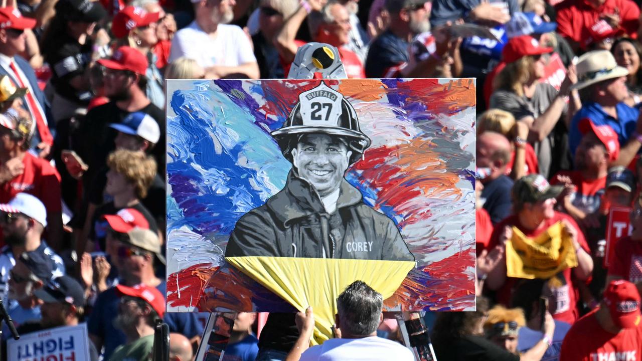 Artist Scott LoBaido unveils a portrait of fireghter Corey Comperatore, who was killed in the assassination attempt. Picture: Jim WATSON / AFP