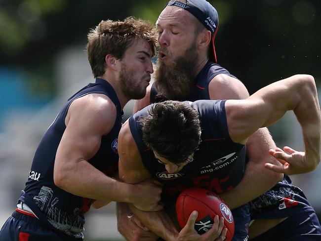 Christian Petracca cops a brutal tackle from Max Gawn and Jack Viney. Picture: Wayne Ludbey