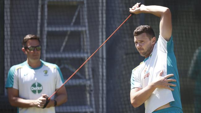 Josh Hazlewood stretches his side as he trains at the MCG. Picture: Getty Images