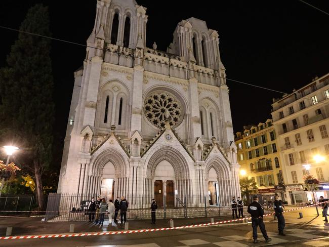 TOPSHOT - Police block the access to the Notre-Dame de l'Assomption Basilica in Nice on October 29, 2020 after a knife-wielding man kills three people in the church, slitting the throat of at least one of them, in what officials are treating as the latest jihadist attack to rock the country. (Photo by Valery HACHE / AFP)