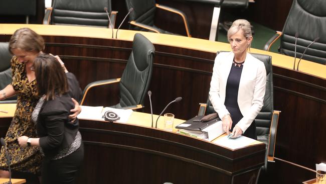 Attorney-General Elise Archer, right, stands after the passage of the laws as Greens leader Cassy O’Connor, left, and Labor’s Shadow Attorney-General Ella Haddad celebrate.