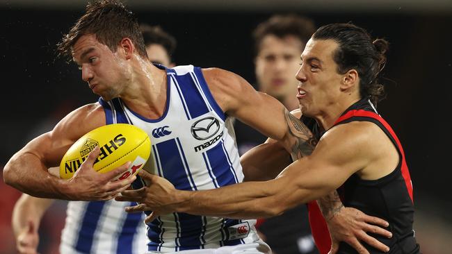 AFL Round 6. Essendon vs North Melbourne at Metricon Stadium, Gold Coast. 11/07/2020.   Jy Simpkin of the Kangaroos tries to break the tackle of Dylan Shiel of the Bombers   . Pic: Michael Klein