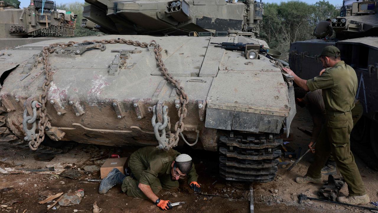 Israeli soldiers gather around tanks near the southern border. Picture: Menahem Kahana/AFP