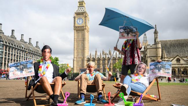 People wearing masks featuring Britain's Prime Minister Boris Johnson (C) and leadership candidates Rishi Sunak (L) and Liz Truss (R) take part in a Labour Party photo-call. Picture: Getty Images.