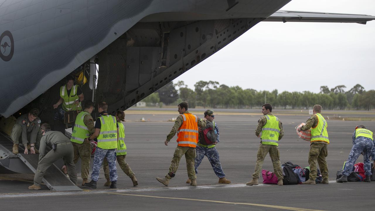 Australian Defence Force personnel unload evacuees belongings from Mallacoota at the RAAF Base East Sale. Picture: Department of Defence