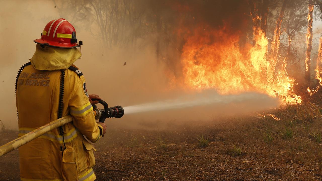 A firefighter battles flames near the town of Old Bar on the NSW Mid North Coast. Picture: AAP