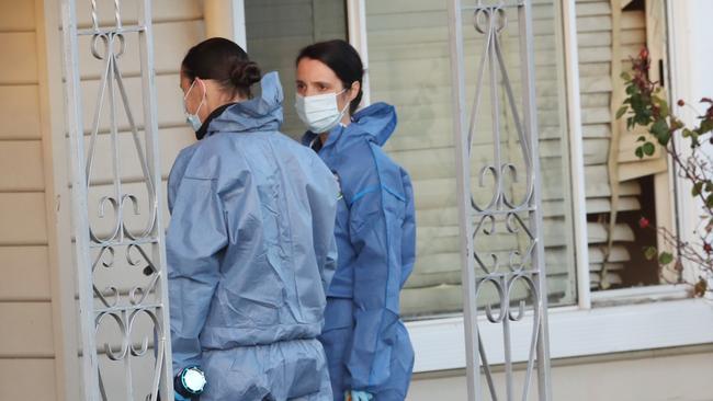 Investigators outside the smashed front window of the Sunshine North home. Picture: David Crosling