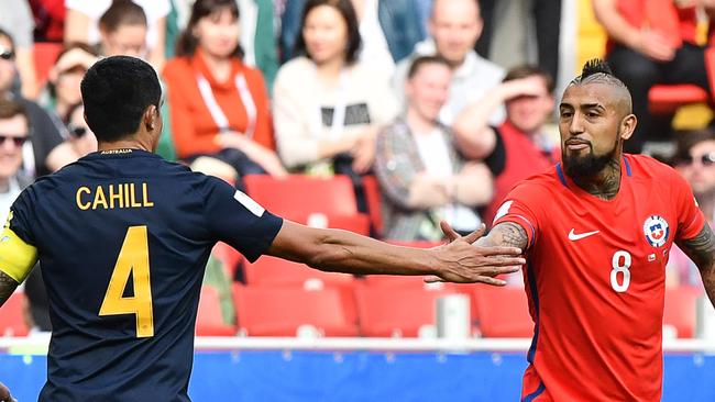 Australia's forward Tim Cahill (L) shakes hands with Chile's midfielder Arturo Vidal.