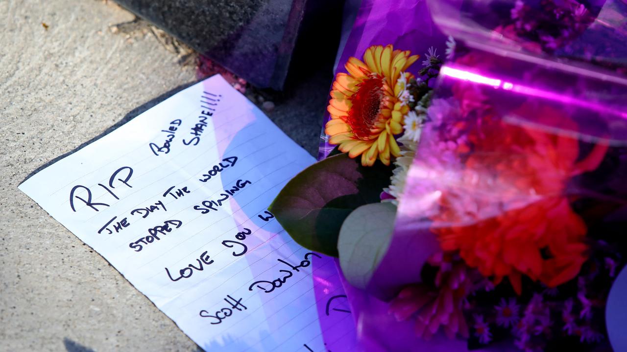 A handwritten message is seen at the base of a statue of late Australian cricket legend Shane Warne