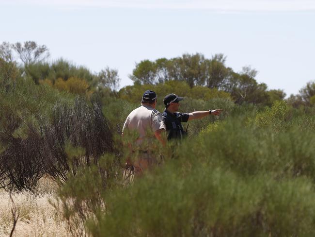 Police and forensic officers examine the area near where Mrs Woodford’s body was found. Picture: Simon Cross