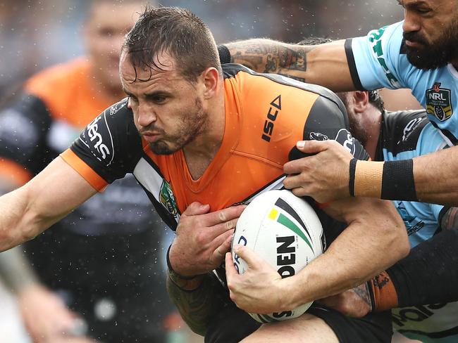 SYDNEY, AUSTRALIA - JUNE 10: Josh Reynolds of the Tigers is tackled during the round 14 NRL match between the Cronulla Sharks and the Wests Tigers at Southern Cross Group Stadium on June 10, 2018 in Sydney, Australia. (Photo by Mark Kolbe/Getty Images)