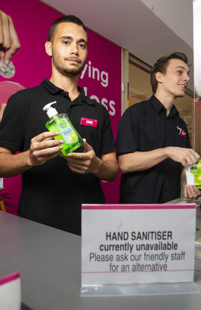 Priceline Alice Springs staff members Mitchell Rosewood (left) and Darcy McKinnon with a sign advising customers that hand sanitiser is not available for purchase. Picture: Kevin Farmer