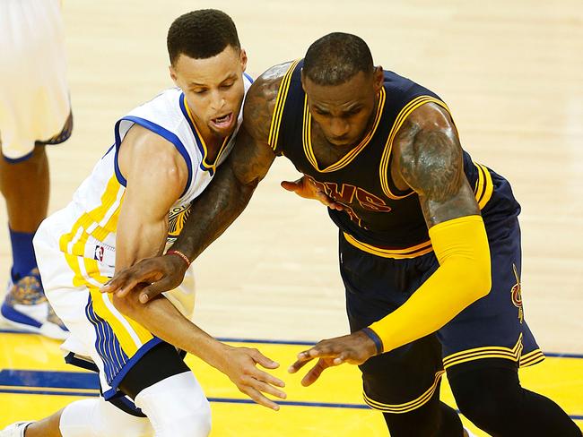 Golden State Warriors guard Stephen Curry (left) and Cleveland Cavaliers forward LeBron James scramble for a loose ball during the second quarter of game 1 of the NBA Finals on June 2, 2016 in Oakland, California.  / AFP PHOTO / Beck Diefenbach