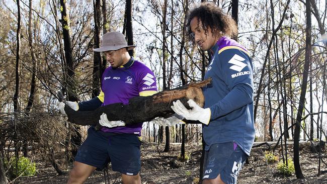 Felise Kaufusi and Kelma Tuilagi remove burnt logs.