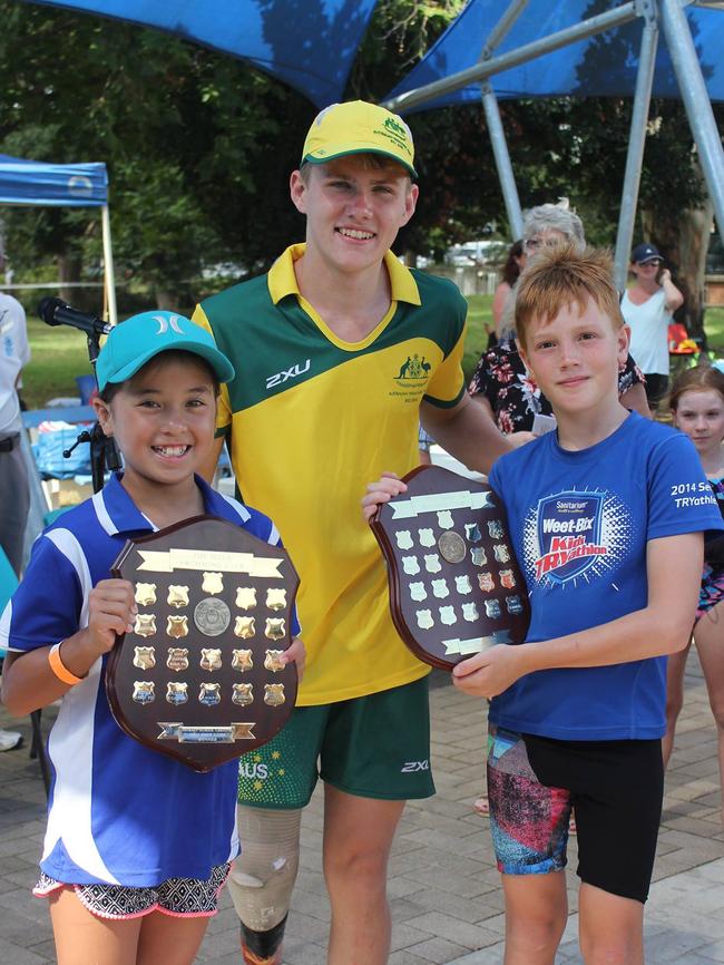 Paralympian and club member Timothy Hodge presents Jasper Road students Kanako Delaney and Joel Thomas with the Primary School Shields at The Hills Swimming and Life Saving Club's 50th anniversary celebrations on February 12.