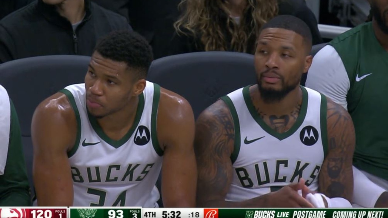 Giannis and Dame watch on from the bench.