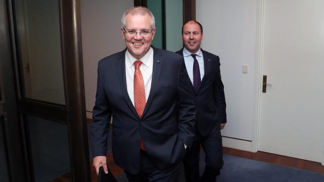 Prime Minister Scott Morrison and Treasurer Josh Frydenberg make their way to the press conference on Monday night. Picture: Gary Ramage