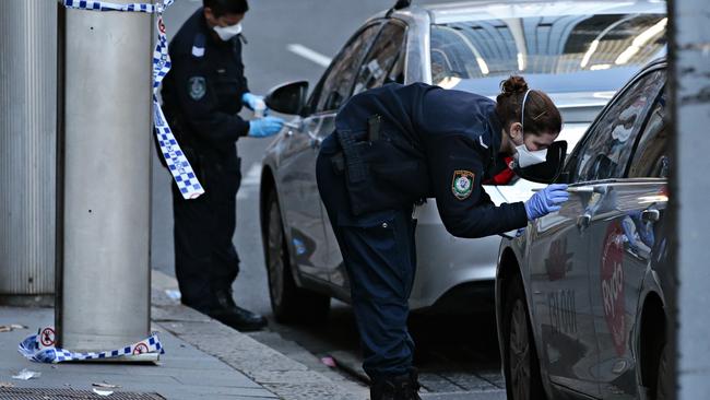 Police search for evidence at the crime scene where gangster Bilal Hamze, above right, was brutally executed on Sydney’s Bridge St. Picture: Adam Yip