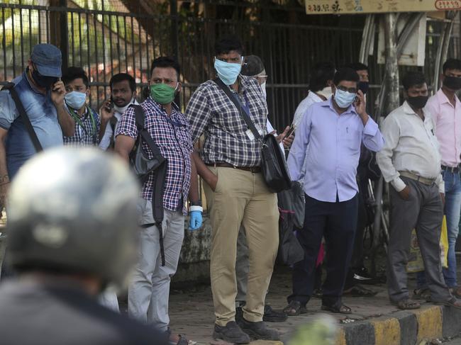 People wait for a bus in Mumbai, India. Picture: AP