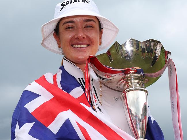 SINGAPORE, SINGAPORE - MARCH 03: Hannah Green of Australia poses with the trophy on the 18th green whilst wearing the Australian flag following victory on Day Four of the HSBC Women's World Championship at Sentosa Golf Club on March 03, 2024 in Singapore. (Photo by Andrew Redington/Getty Images)