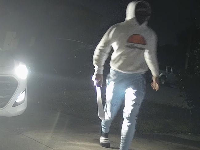 CCTV showing one of the men clutching a machete.