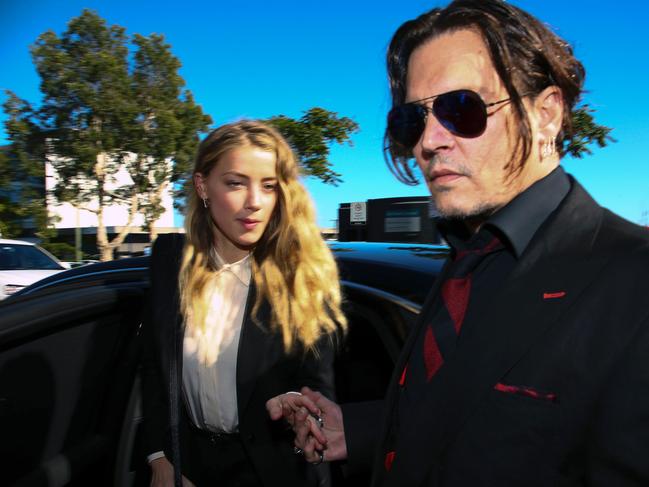 US actor Johnny Depp (R) and his wife Amber Heard arrive at a court in the Gold Coast on April 18, 2016.  Depp and Heard arrived at an Australian court April 18 over Heard's alleged illegal importation of their two Yorkshire terrier dogs Boo and Pistol into the country in a private jet in 2015, as Depp was in Australia for the filming of the latest Pirates of the Carribean movie.    / AFP PHOTO / Patrick HAMILTON