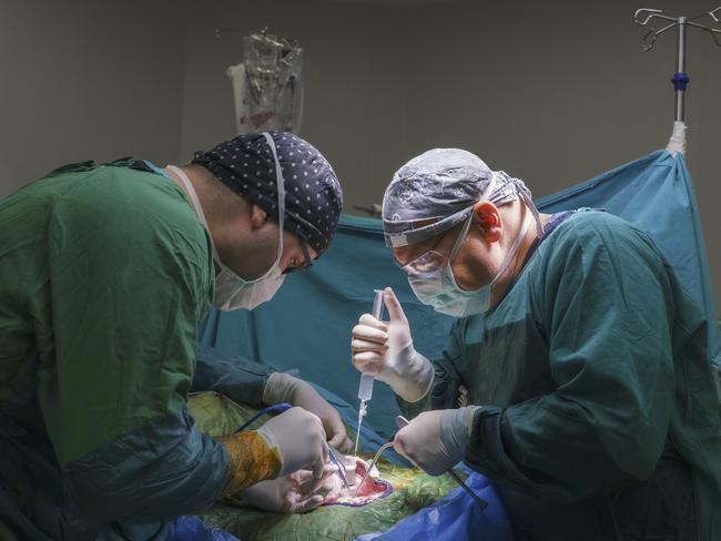 Neurosurgeon team operating brain tumor surgery in hospital operating room