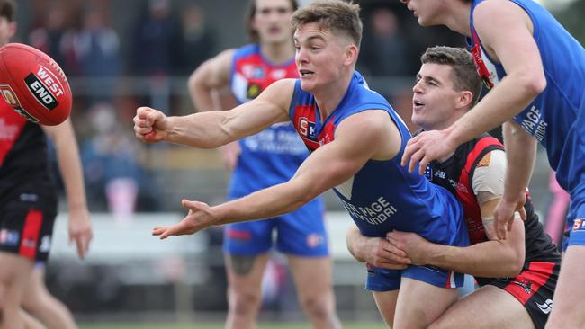 Central District’s Harry Grant handballs under pressure from West Adelaide’s Michael Mattingly. Picture: David Mariuz/SANFL