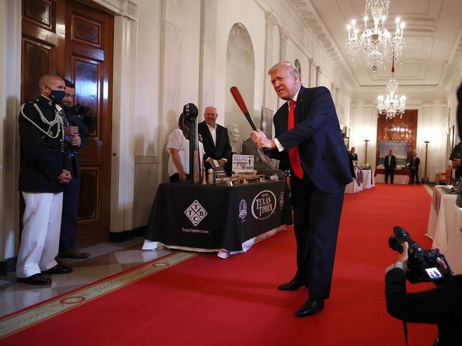 WASHINGTON, DC - JULY 02: U.S. President Donald Trump holds a baseball bat while looking at exhibits during a Spirit of America Showcase in the Entrance Hall of the White House July 02, 2020 in Washington, DC. The president visited with representatives from invited companies like Weber-Stephen Products, the Texas Timber Wood Bat Company, Scars & Stripes Coffee, Carolina Pie, Fruit of the Earth, Nautilus Fishing Company and others. (Photo by Chip Somodevilla/Getty Images)