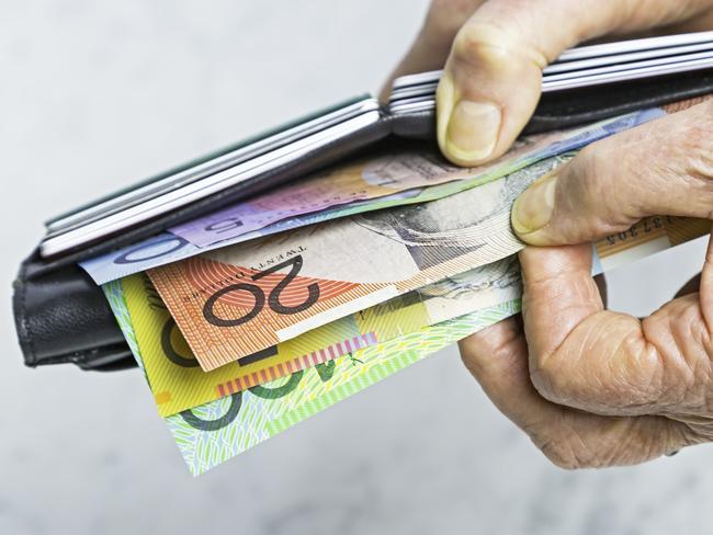 Payment: Close-up, senior female hands taking Australian banknotes (cash, currency) from purse containing many credit cards.  Horizontal, studio, copy space. Money generic