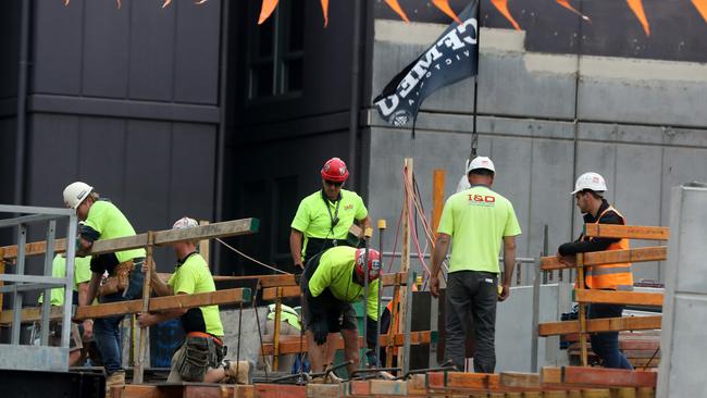 Construction workers on a building site with a CFMEU flag attached to a crane in South Yarra. A new report has found Melbourne construction costs are among the world’s most expensive. Picture David Geraghty/The Australian