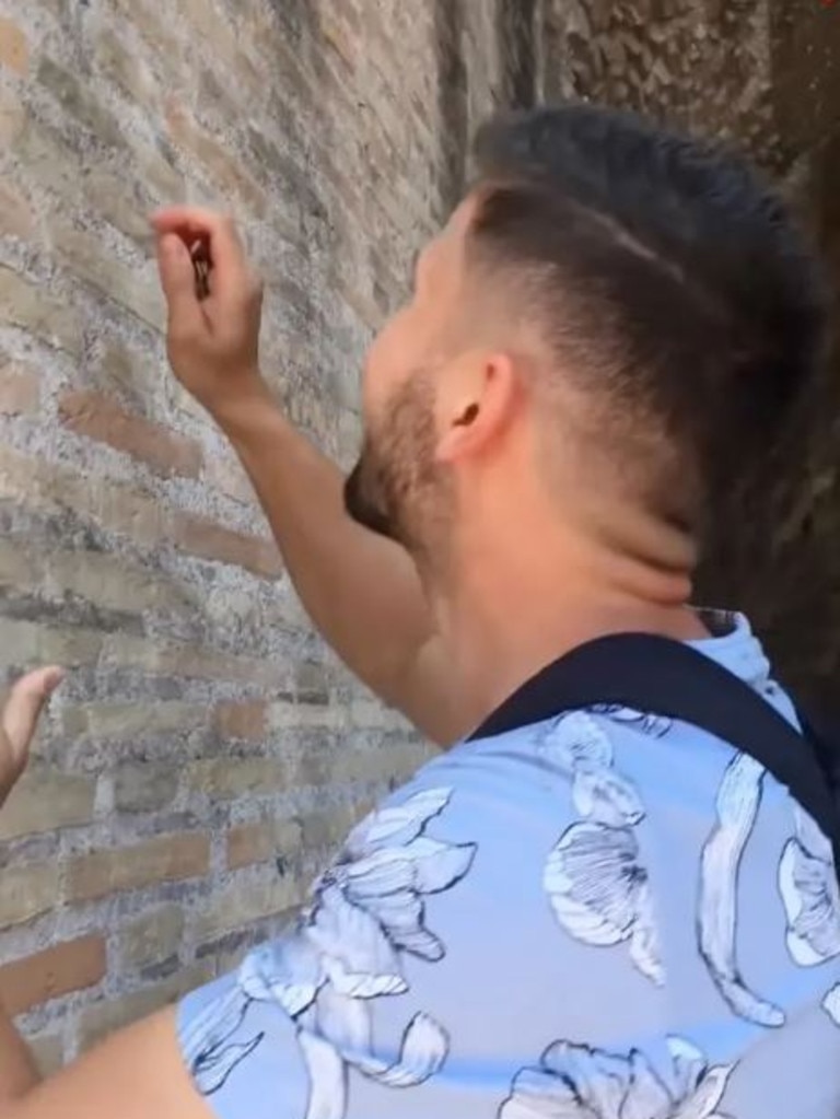 A man is facing a $24,550 fine for engraving names into the walls of the Roman Colosseum using a set of keys. Picture: YouTube