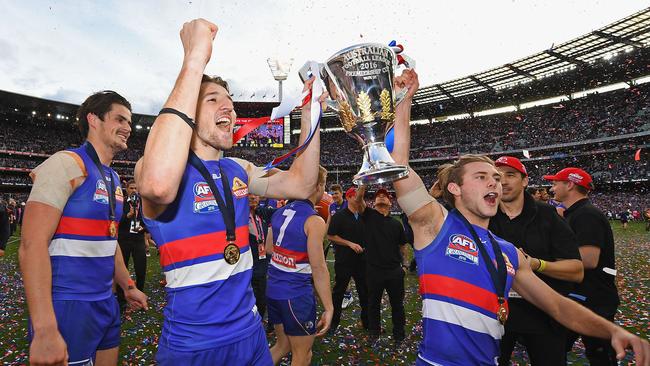 Caleb Daniel holds the premiership cup aloft with Marcus Bontempelli.