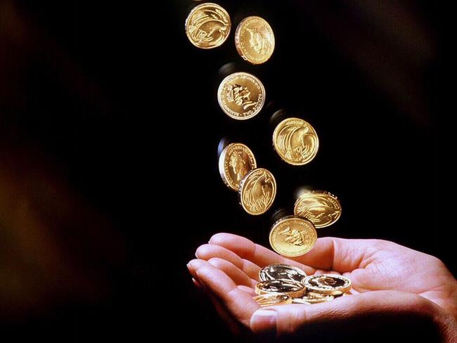 Undated photo. Gold one dollar coins being poured into a hand. coin falling currency money. Z-Migr-AllFuturePic